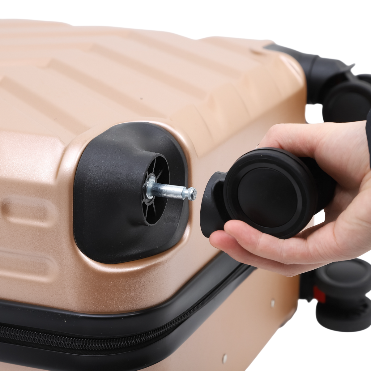 Nomado Horizon suitcase in gold with wheels – a person fitting a wheel