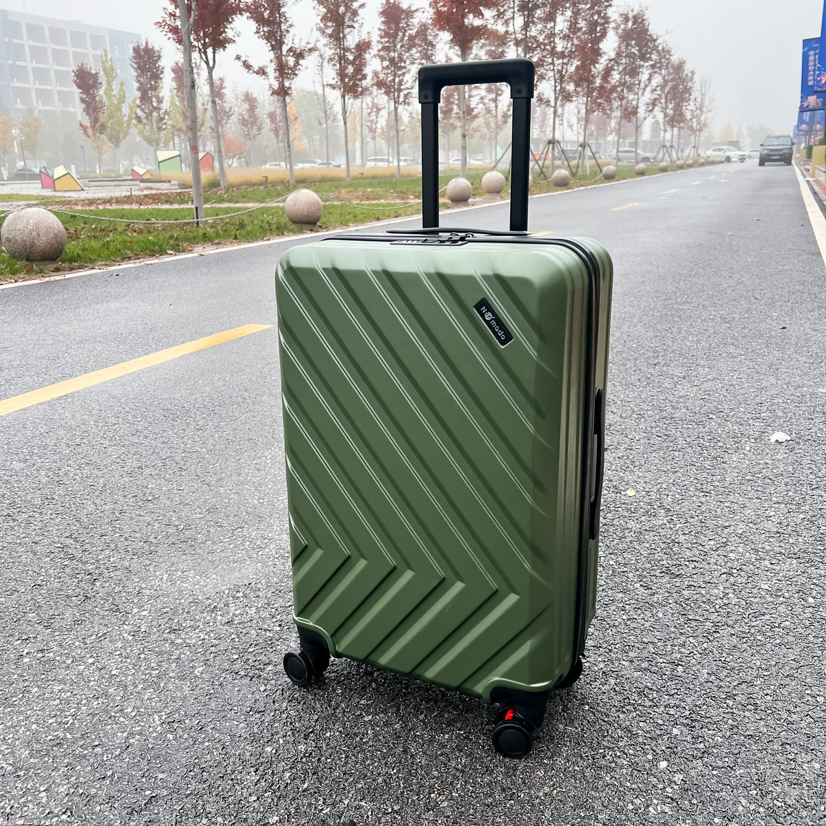 Nomado Horizon 2.0 suitcase in green – on asphalt