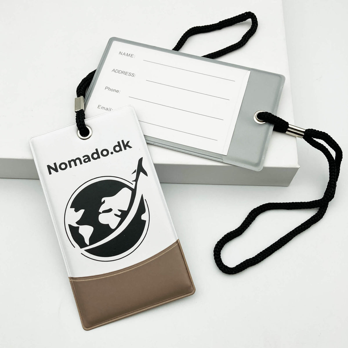 Nomado luggage tags: blue tag with logo and grey tag with contact information